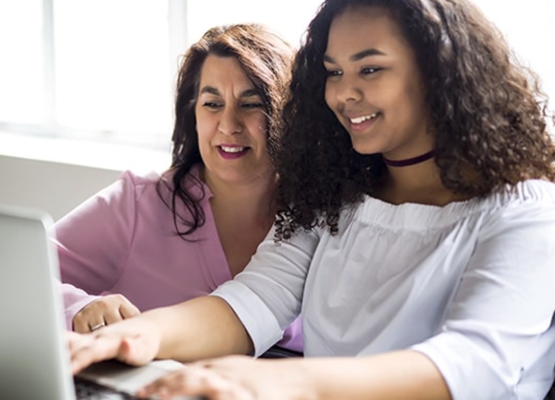 student with her mom doing school works online